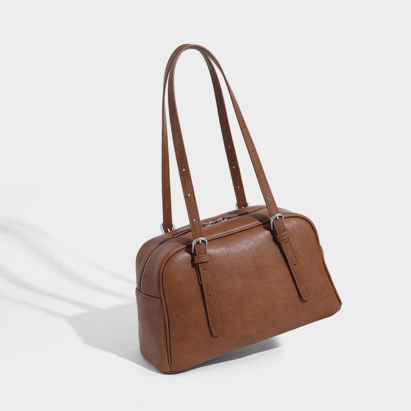 Structured dome-shaped shoulder bag with leather-look finish, top zipper closure, dual adjustable slim straps, and, detail