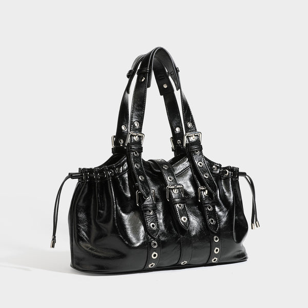 Large black glossy leather-look tote bag with silver buckle straps, eyelet grommet panels, drawstring side gathers, and