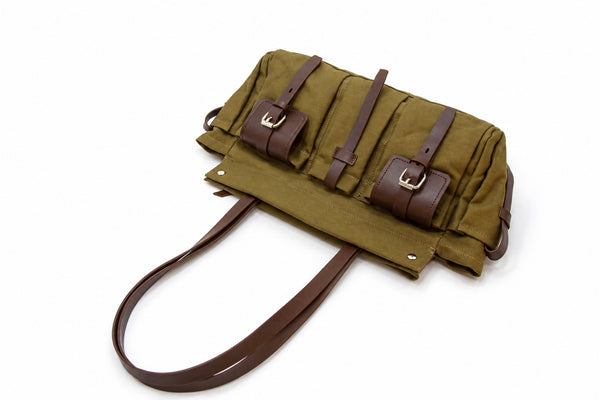 Large olive canvas shoulder tote bag with multiple front buckle-strap pockets and dark brown leather-look trim, detail view