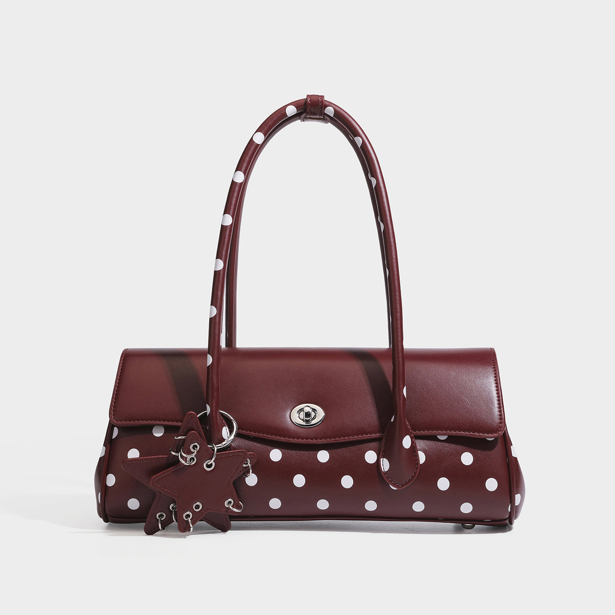 Formstabile Baguette-Tasche mit Polka-Dot-Muster, glänzender Oberfläche in Lederoptik, zwei Tragegriffen, silberfarbenem Drehverschluss an der Umschlagklappe und