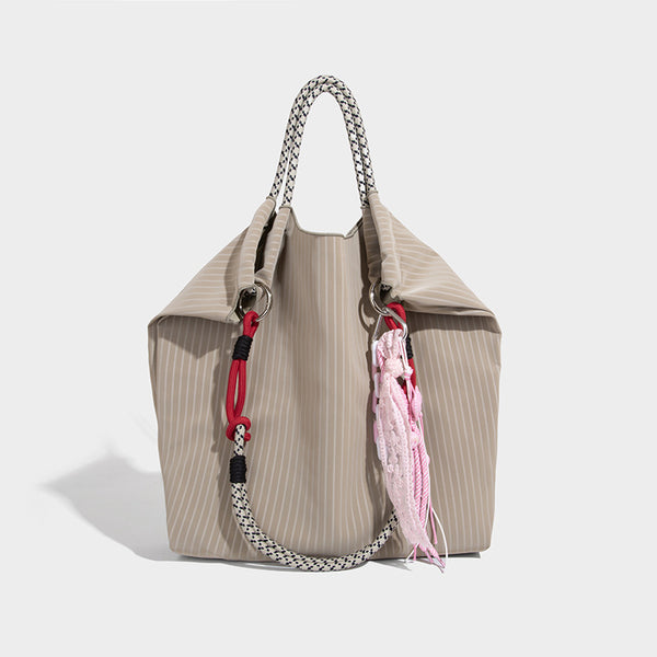 Slouchy pinstripe tote bag with braided rope handles, metal ring hardware, and colorful knotted rope charm, detail view 9