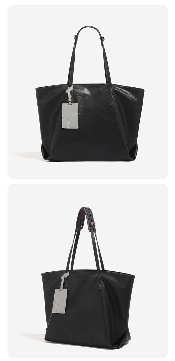 Oversized slouchy leather-look tote bag with long shoulder straps, contrast grey hanging tag, and silver-tone hardware