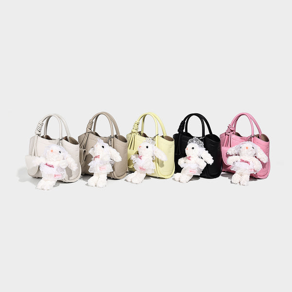 Structured mini tote bag in pebbled leather-look finish with knotted top handles, front flap pocket, and detachable shoulder