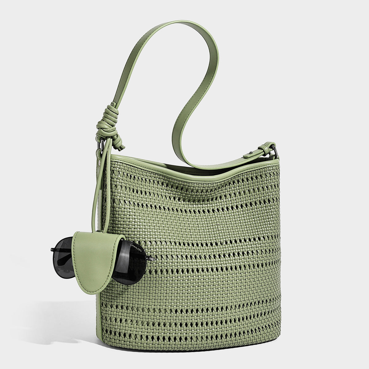 Handwoven open-weave shoulder bag with leather-look trim, knotted adjustable strap, and clip-on sunglasses sleeve pouch