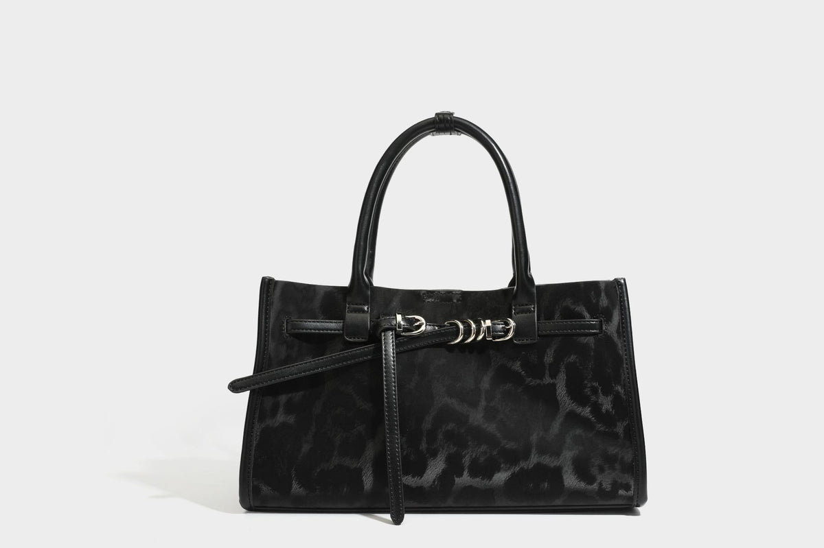 Structured leopard-print tote bag with glossy satin-like finish, dual rounded top handles, silver buckle-and-ring front