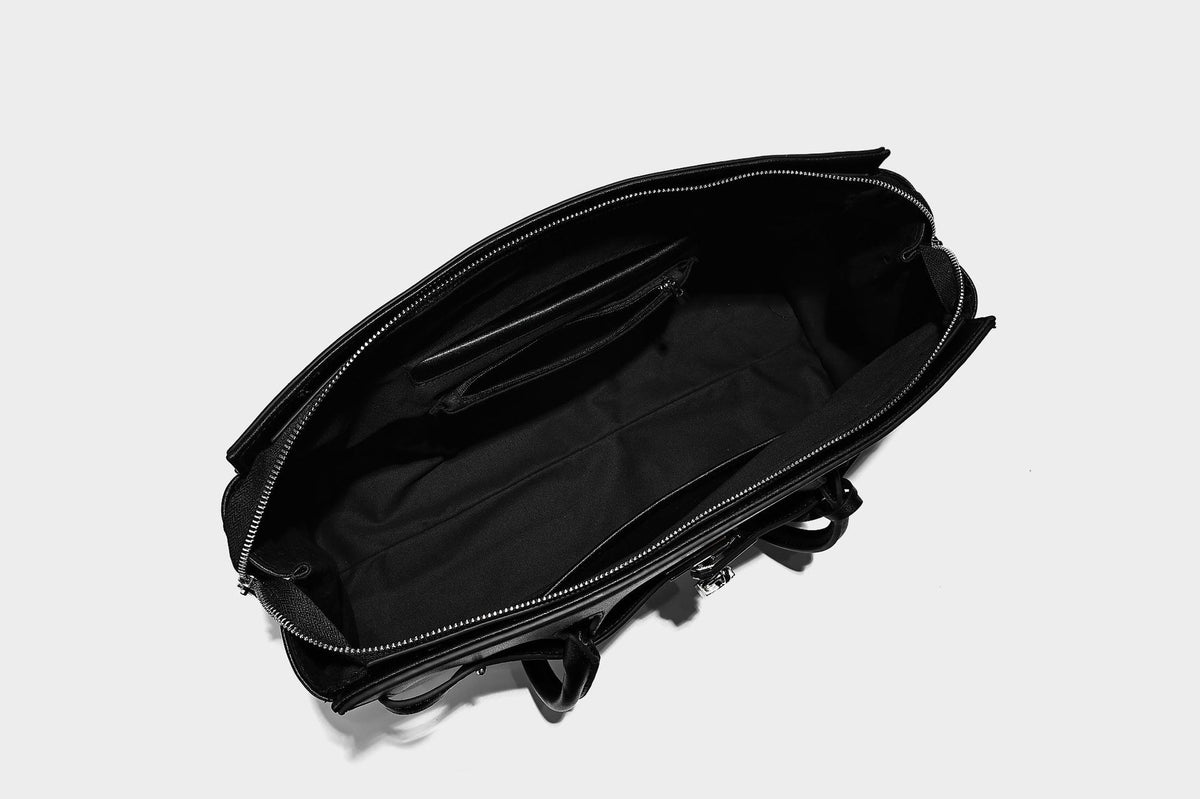Strukturierte Tote-Bag in schwarzer Lederoptik mit Drehverschluss in Vorhängeschloss-Optik, dekorativen Riemendetails und abgerundeten Doppelhenkeln