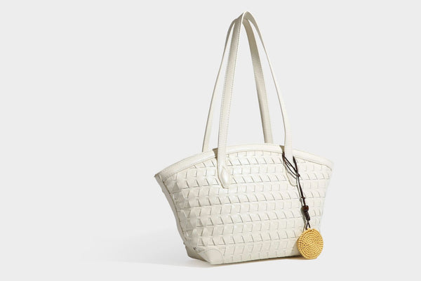 Large leather-look tote bag with geometric woven emboss, double shoulder straps, and round woven cord charm in brown, detail
