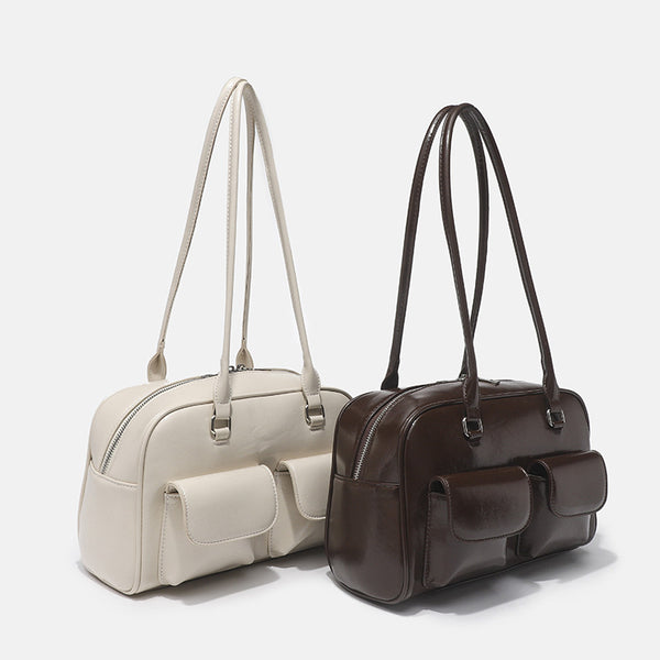 Structured glossy leather-look bowling shoulder bag with two front flap pockets, top zip closure, and long double shoulder