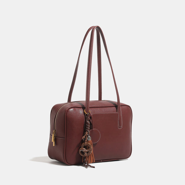 Structured rectangular leather-look shoulder bag with top zip, tassel and resin ring charm, and contrast topstitching, detail