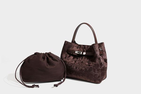 Small structured bucket satchel in embossed velvet-texture fabric with silver turn-lock hardware, rounded top handle, and