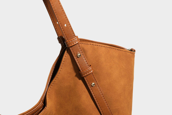 Oversized suede-finish tote shoulder bag in caramel brown with slim leather-look straps and gold-tone logo hardware, detail