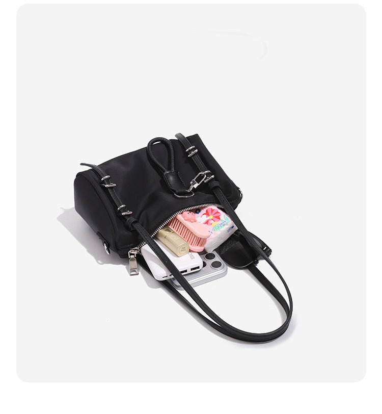 Compact nylon Boston barrel bag with zip-top closure, silver-tone hardware, dual slim handles, and detachable crossbody