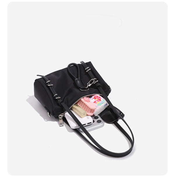 Compact nylon Boston barrel bag with zip-top closure, silver-tone hardware, dual slim handles, and detachable crossbody