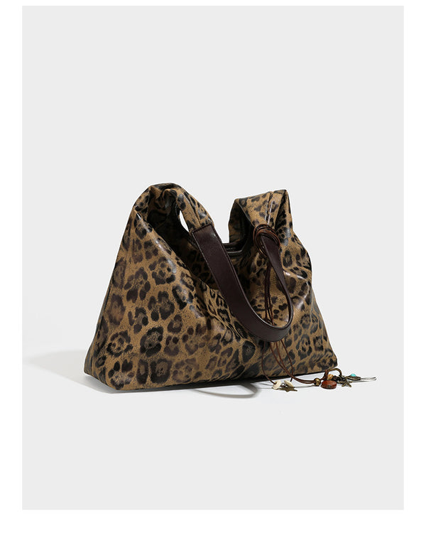 Weich fallende Hobo-Tote-Bag mit Leopardenmuster in Beige und Braun, dunkelbraunem Riemen in Lederoptik und herabhängenden Perlenanhänger-Beschlägen