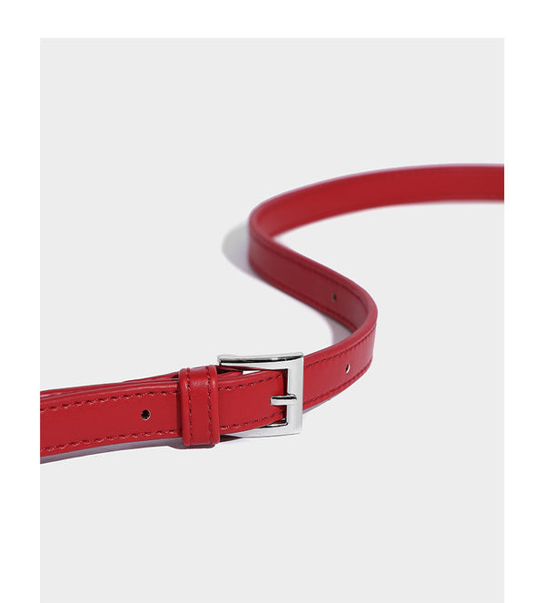 Small structured shell top-handle bag in red with heart charm and braided cord detail, smooth leather-look finish, detail