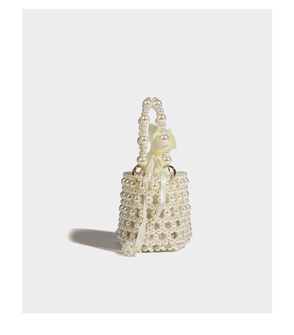 Elfenbeinfarbene Mini-Bucket-Bag aus Kunstperlen mit Satin-Innenbereich und Zugband, goldfarbenen Ringbeschlägen und gewölbtem Perlenhenkel an der Oberseite