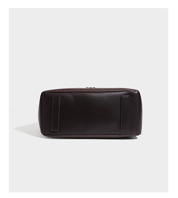 Structured pebbled leather-look shoulder bag with flap top, gold-tone emblem hardware, dual top handles, and detachable