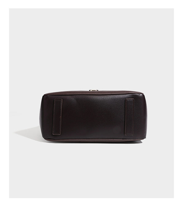 Structured pebbled leather-look shoulder bag with flap top, gold-tone emblem hardware, dual top handles, and detachable