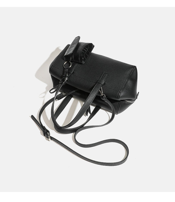 Structured pebbled leather-look top-zip barrel bag with dual handles, detachable shoulder strap, and attached croc-pattern