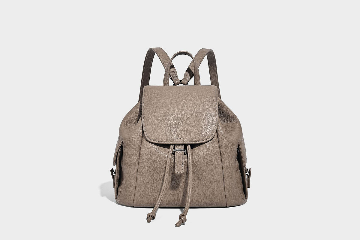 Compact pebbled leather-look flap drawstring backpack handbag with side pockets, top handle, and silver-tone hardware, detail