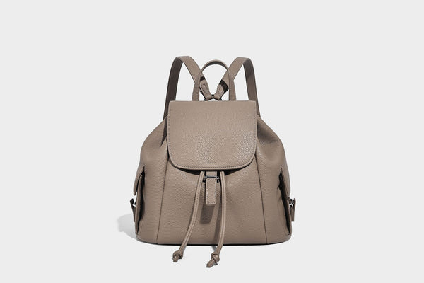 Compact pebbled leather-look flap drawstring backpack handbag with side pockets, top handle, and silver-tone hardware, detail