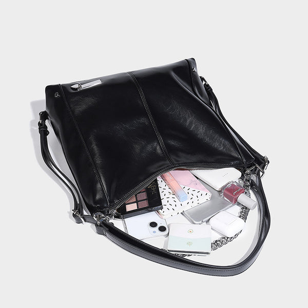 Glänzend schwarze, weich fallende Hobo-Tote-Bag mit silberfarbenem Kettenelement, Reißverschluss oben und langen Schulterriemen, Detailansicht 4