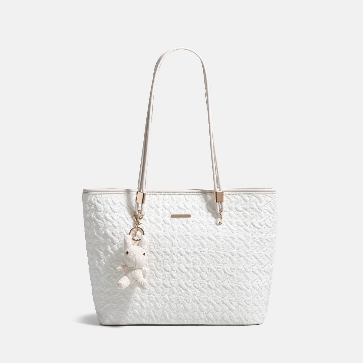 Off-white structured tote bag with dual shoulder straps, gold-tone hardware, and plush bear charm, detail view 7