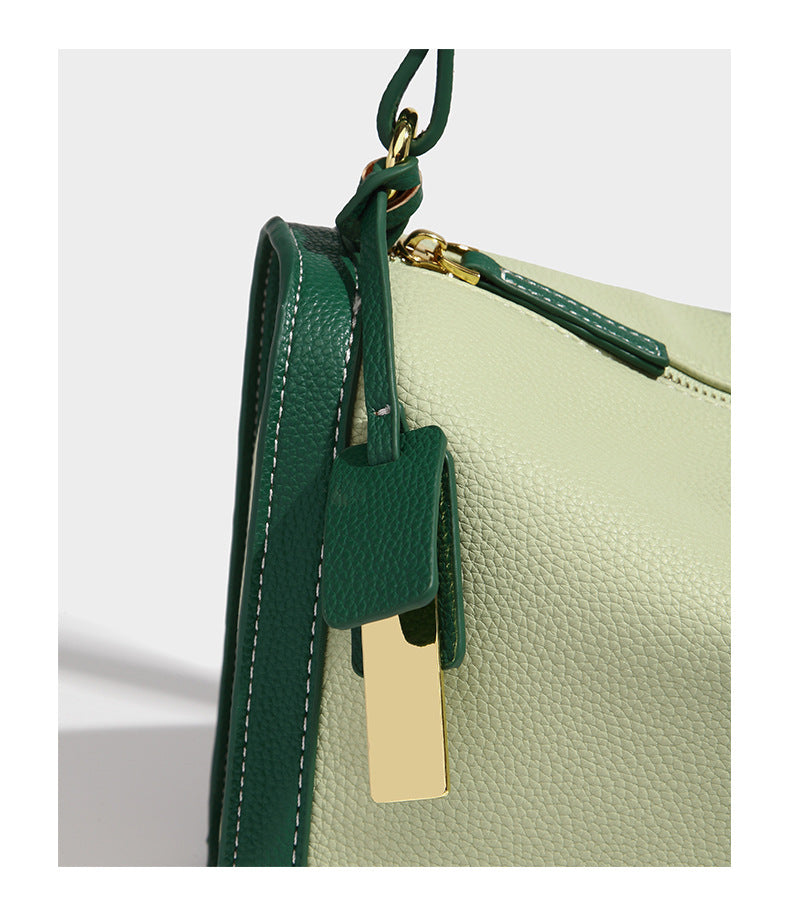 Structured two-tone shoulder bag with pebbled leather-look finish, contrast trim, top zip closure, and gold-tone hardware