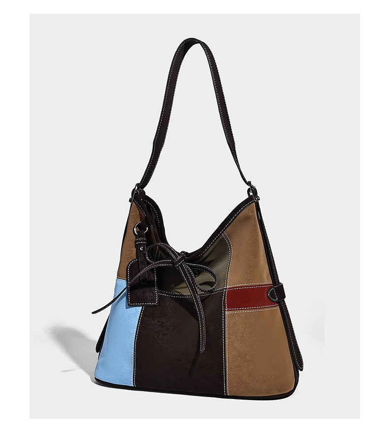 Patchwork bucket tote shoulder bag with tan, dark brown, olive, red, and sky blue color-block panels, white contrast, detail