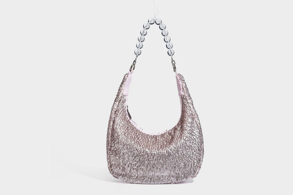 Kleine sichelförmige Schultertasche mit vollständig mit silberfarbenen Pailletten besetzter Außenseite, transparentem Henkel aus kugelförmigen Perlen und Reißverschluss in Silberoptik