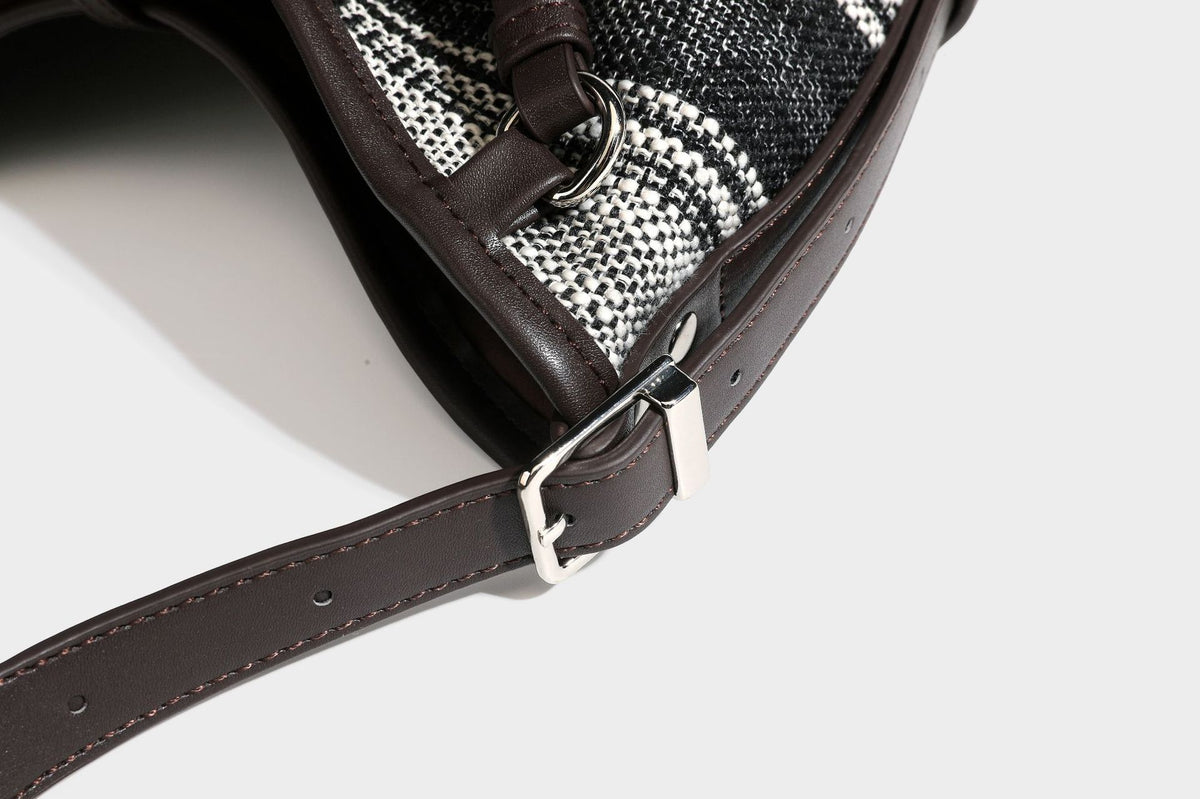 Schwarz-weiß karierte Hobo-Schultertasche aus gewebtem Material mit dunkelbrauner Einfassung in Lederoptik, Kordelzugverschluss und langem, verstellbarem