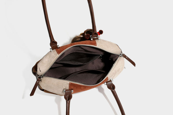 Patchwork suede-look barrel shoulder bag in brown, rust, tan, beige, and gray panels with double leather-look straps and