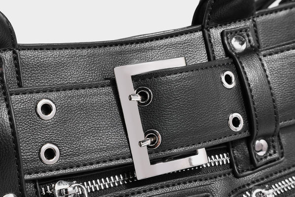 Black structured rectangular satchel bag with silver-tone rivets, large front buckle strap, zip pockets, dual top handles