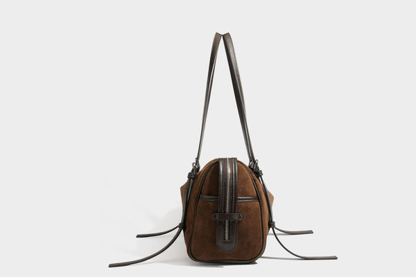 Large brown suede-finish barrel shoulder bag with dark leather-look trim, silver-tone zippers, dual top handles, and long
