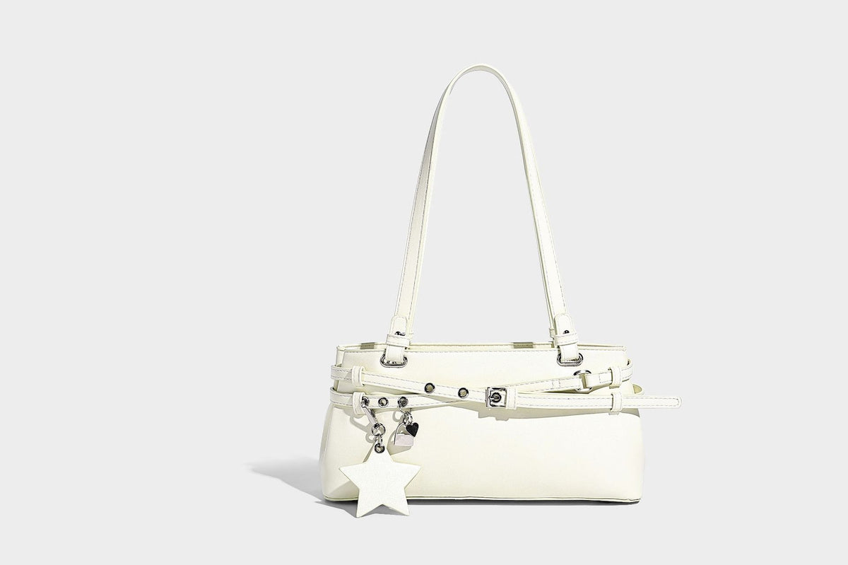 Structured glossy leather-look shoulder bag with wraparound belt straps, silver-tone hardware, and dangling star charm