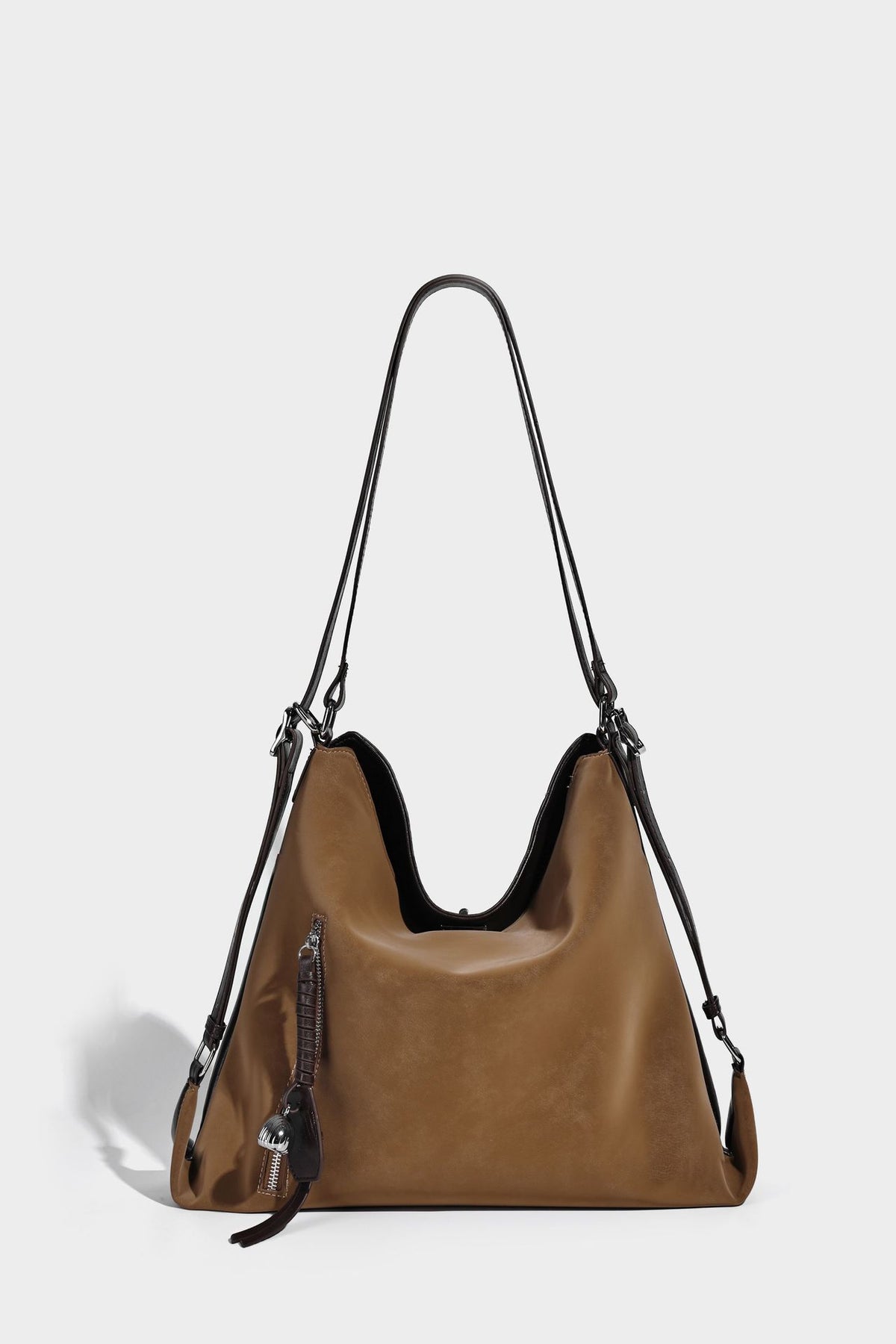 Slouchy hobo tote bag with matte leather-look finish, triangular silhouette, front zip pocket, and adjustable shoulder strap