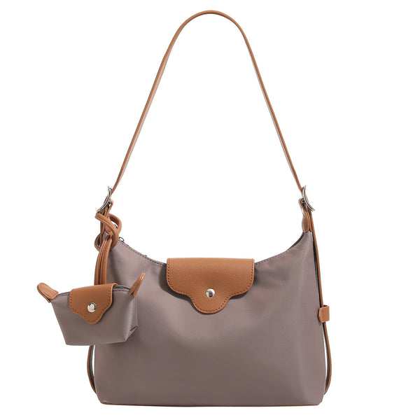Slouchy hobo shoulder bag in smooth fabric with leather-look tan trim, zip-top closure, adjustable strap, and detachable