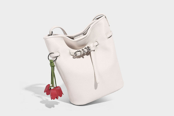 Small pebbled leather-look bucket bag with front drawstring toggle hardware and long adjustable shoulder strap, detail view
