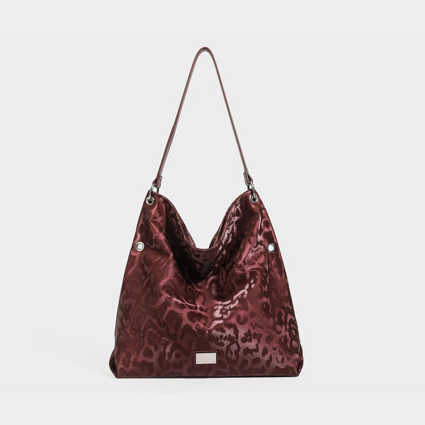 Große, weich fallende Schulter-Tote-Bag mit glänzendem Leopardenmuster in Braun und Schwarz, schmalem Riemen in Lederoptik und silberfarbenen