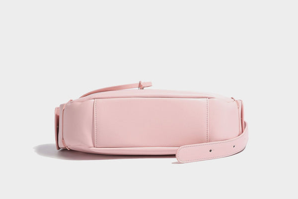 Smooth leather-look crescent shoulder bag with front zip pocket, side flap pockets, adjustable strap, and silver-tone, detail