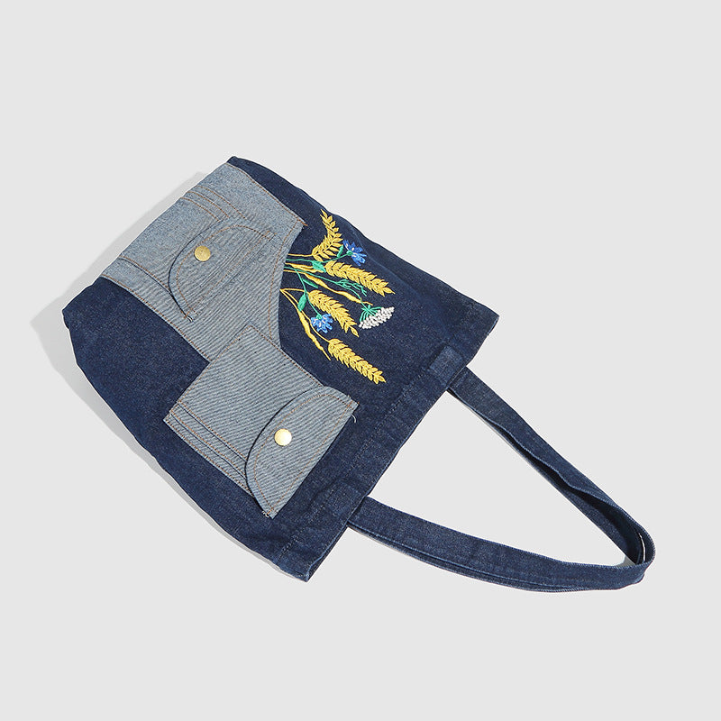 Schulter-Shopper aus marineblauem und hellblauem Patchwork-Denim-Canvas mit Weizen- und Wildblumenstickerei sowie Druckknopf in Antikgoldoptik