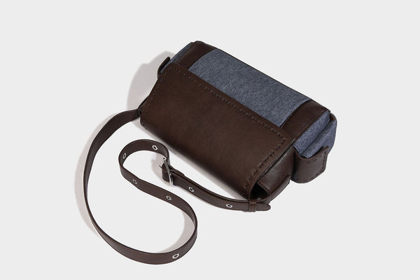 Structured flap crossbody bag in dark brown and cream color-block with white contrast stitching, adjustable shoulder strap