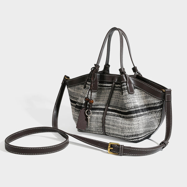 Schwarz-weiße gewebte Trapez-Tote-Bag mit dunkler Verzierung in Lederoptik, weißen Kontrastnähten und zwei Henkeln oben, Detail