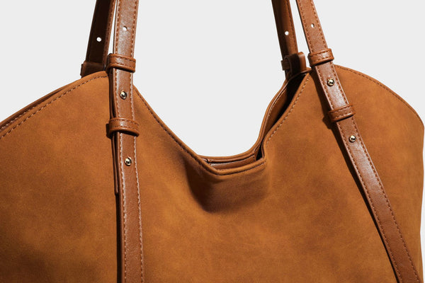 Oversized suede-finish tote shoulder bag in caramel brown with slim leather-look straps and gold-tone logo hardware, detail