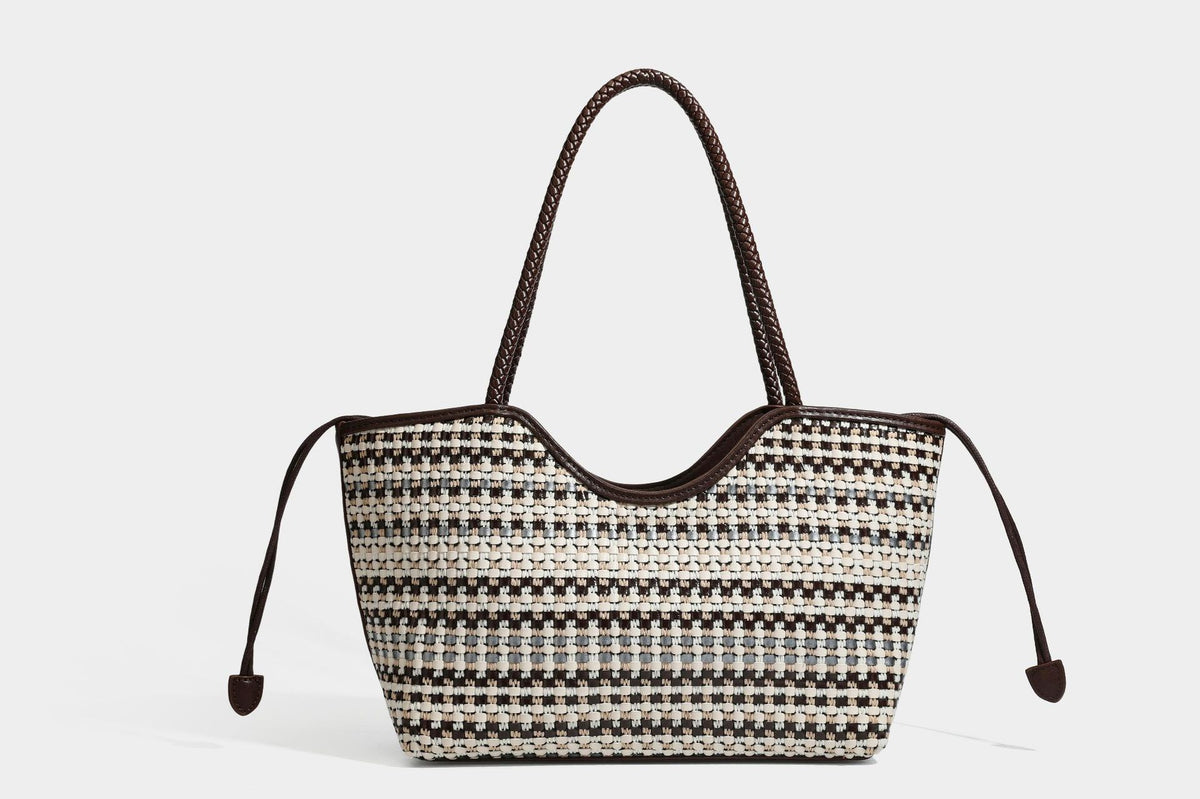 Large woven checker-pattern tote bag with dark braided shoulder straps, leather-look trim, and drawstring side ties, detail