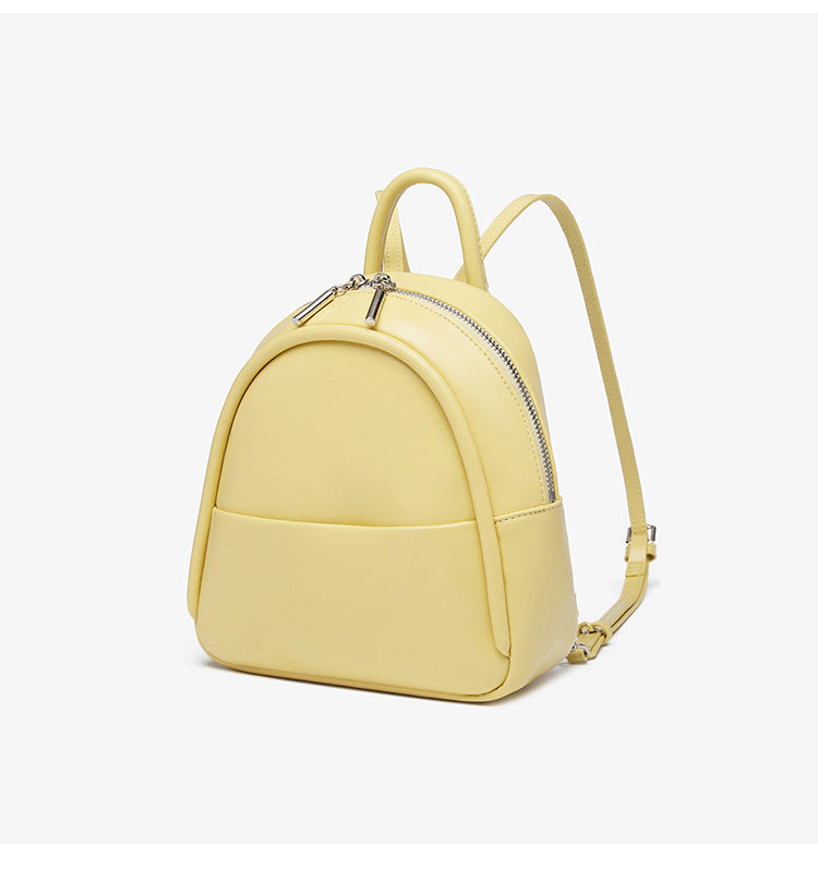 Kleine kuppelförmige Mini-Rucksackhandtasche in Pastellgelb mit glatter Lederoptik, oberem Bogenreißverschluss und silberfarbenen Details, Detailansicht