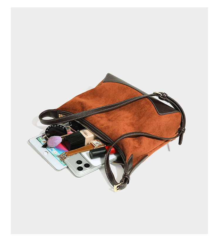 Lässig fallende Hobo-Schultertasche in warmem Braun mit dunkler Kontrastverzierung in Lederoptik, geschwungenem Reißverschluss und langem, detail