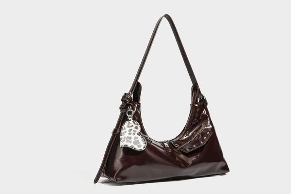 Glossy dark brown hobo shoulder bag with slim strap, front zip pocket, stud detail, and detachable leopard-print heart charm