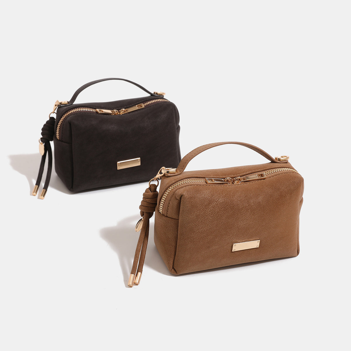 Compact structured rectangular box bag with textured leather-look exterior, top zip closure, short top handle, knotted cord
