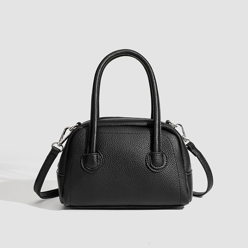 Mini-Boston-Tasche mit genarbter Oberfläche, zwei Tragegriffen, abnehmbarem verstellbarem Crossbody-Riemen und Beschlägen in Silberoptik, Detailansicht
